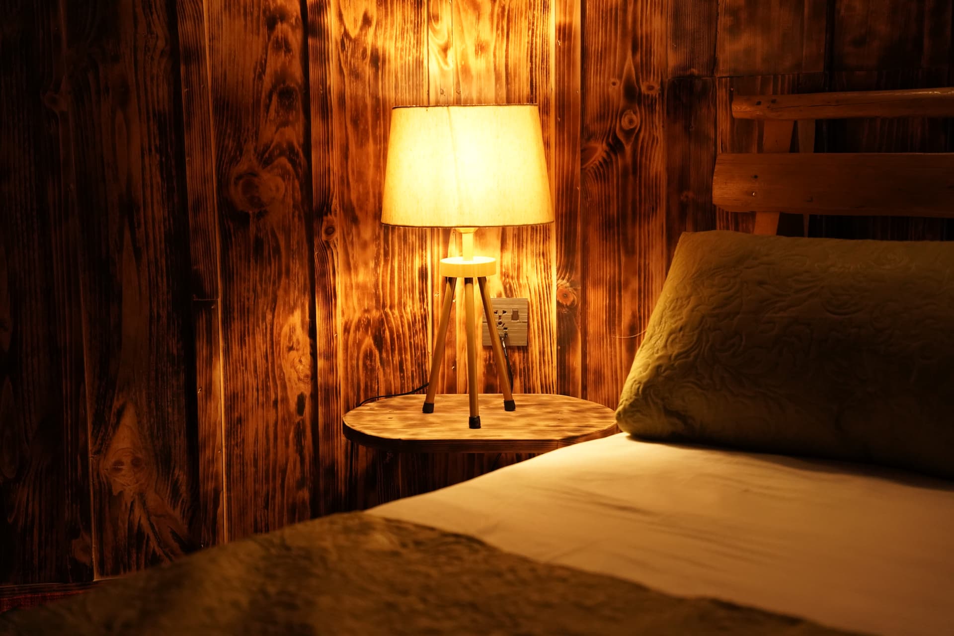 Rustic wooden bedroom with warm lamp lighting