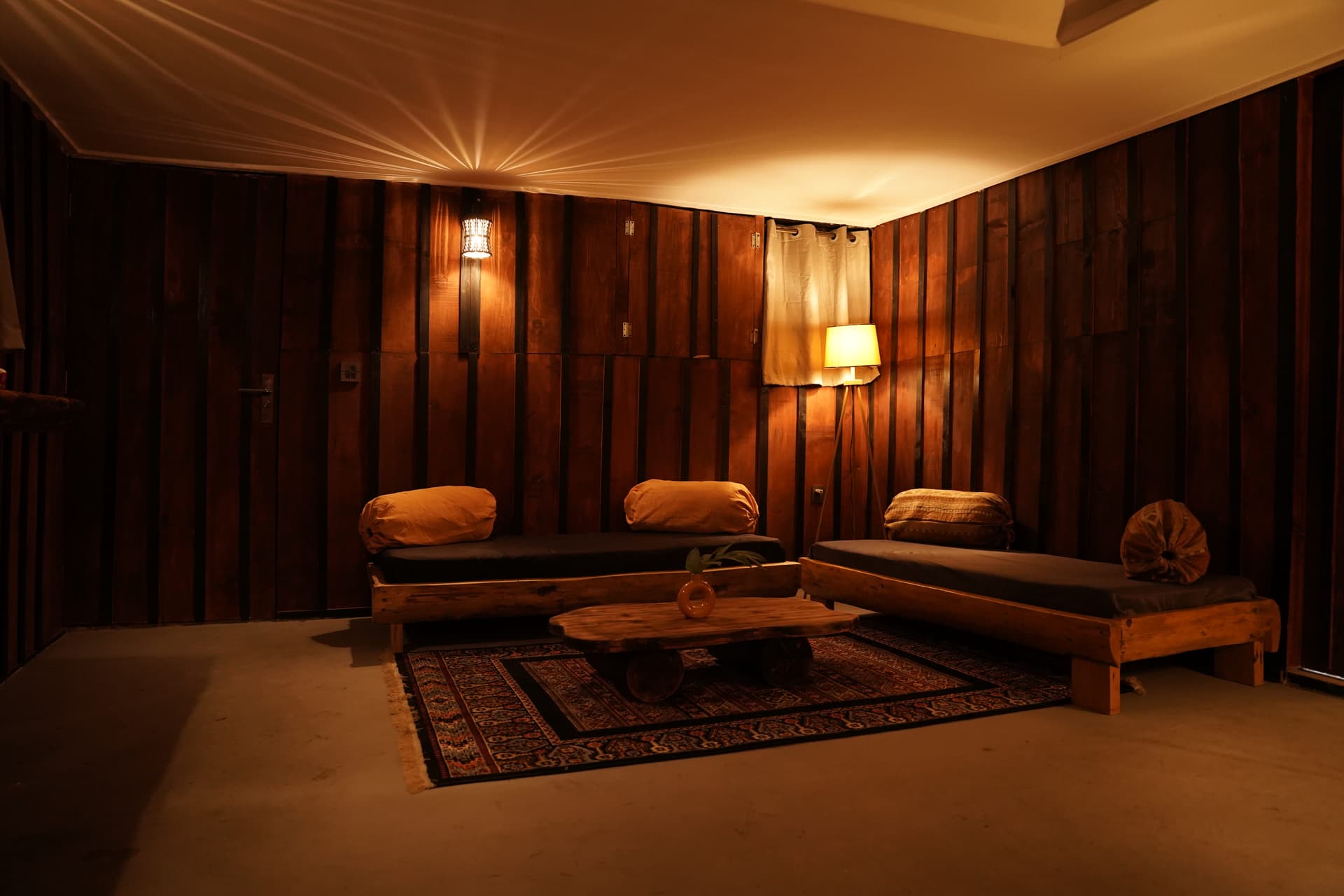 Glamping tent interior with draped fabric ceiling and multiple day beds