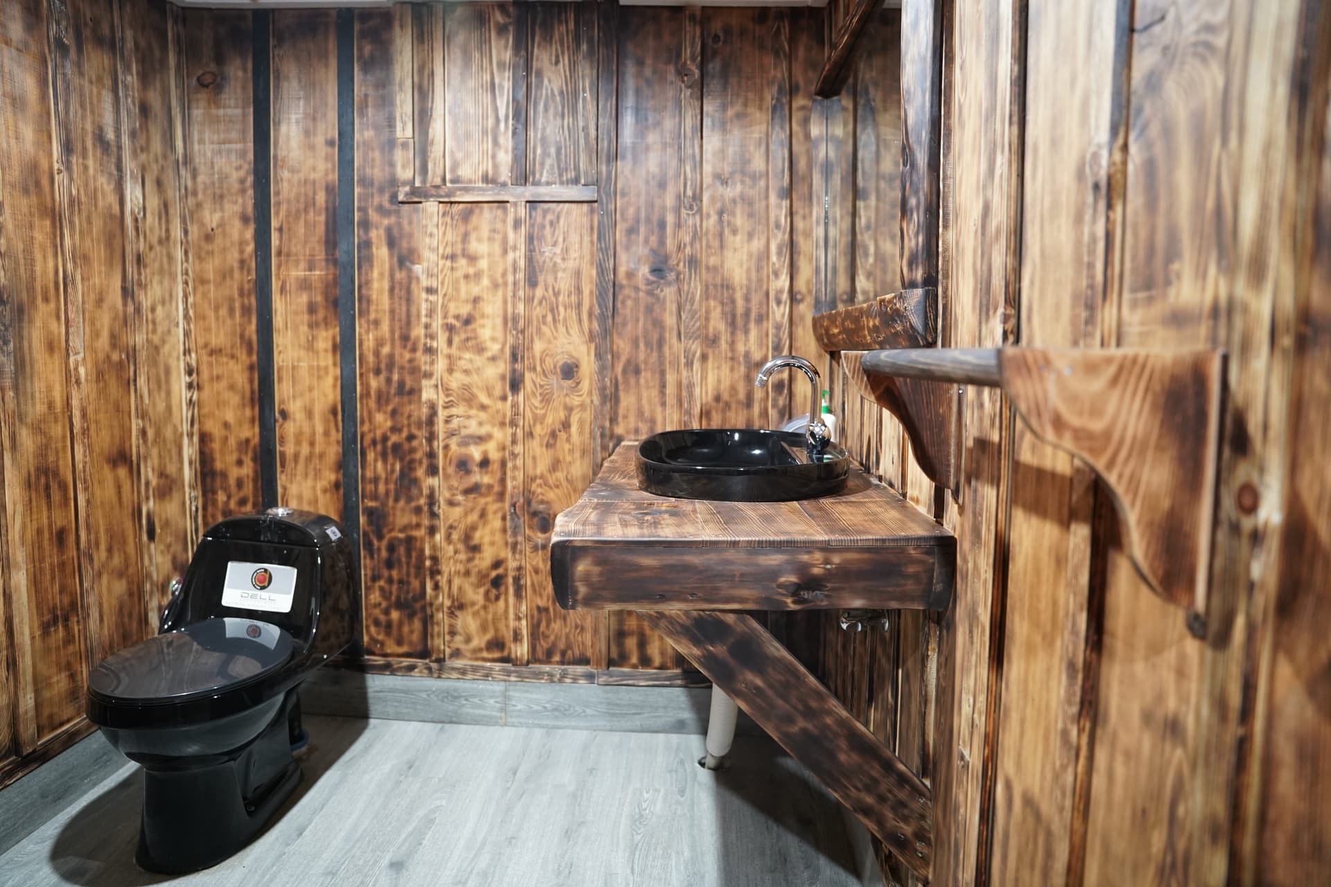 Bathroom with reclaimed wood walls and modern black fixtures
