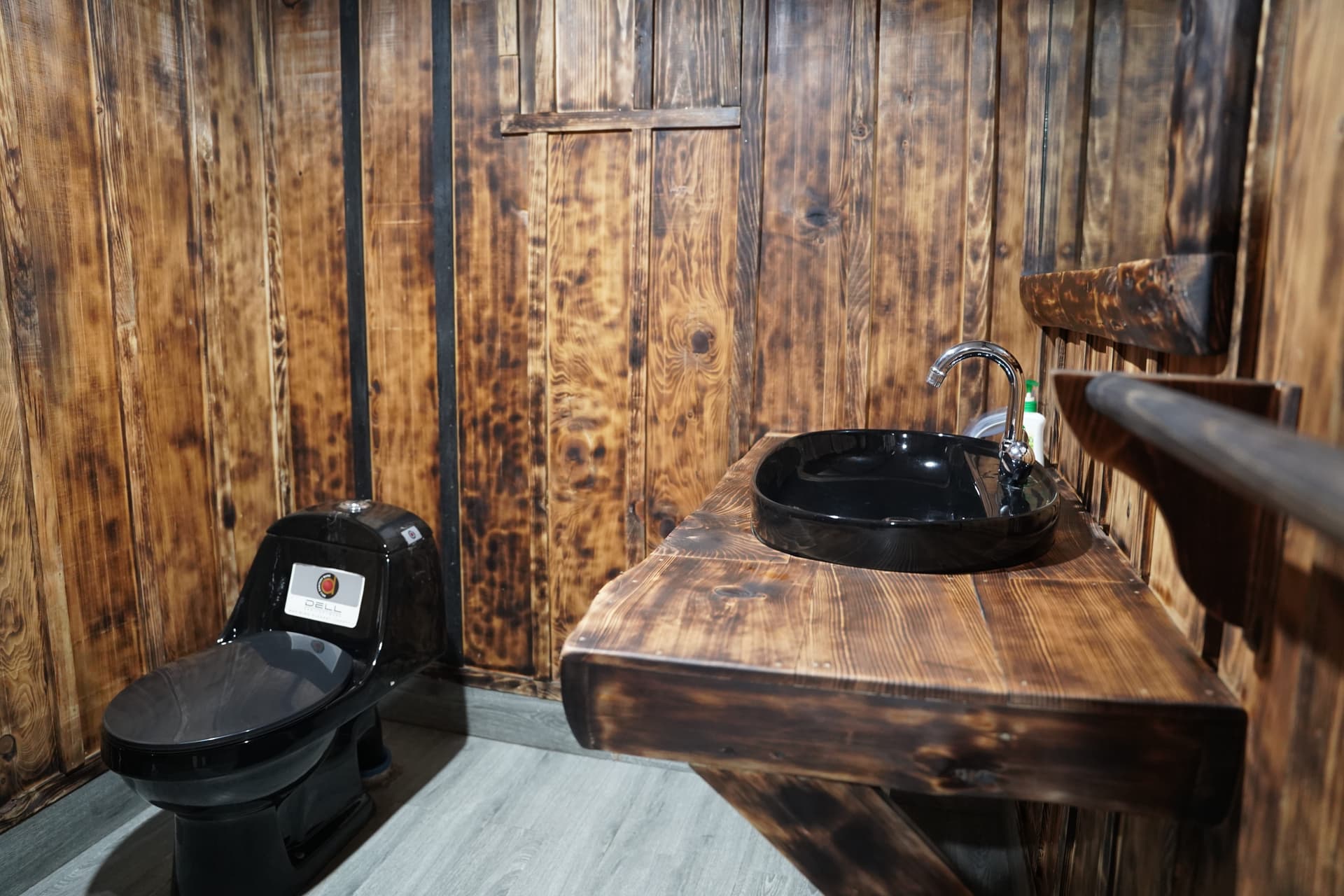 Rustic bathroom with reclaimed wood paneling and modern black fixtures