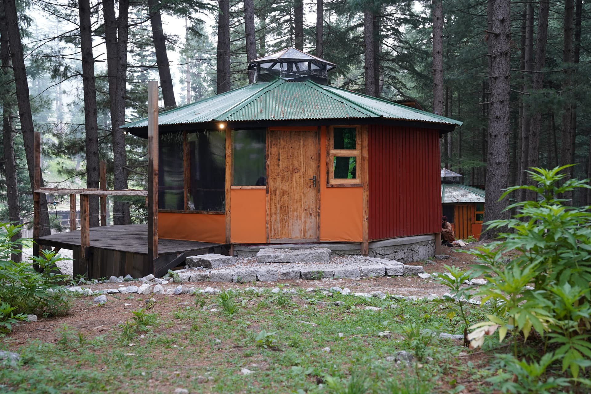 Octagonal orange cabin with cupola surrounded by pine forest